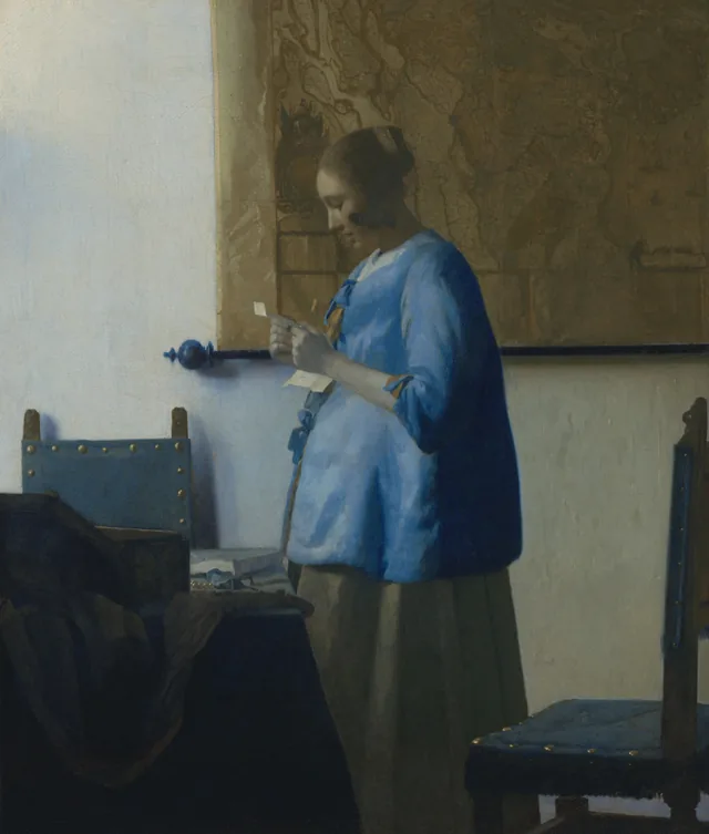 Brieflezende vrouw in het blauw