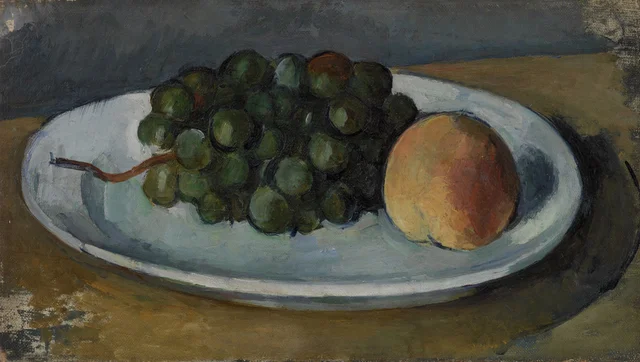 Racimo de uvas y melocotón en un plato