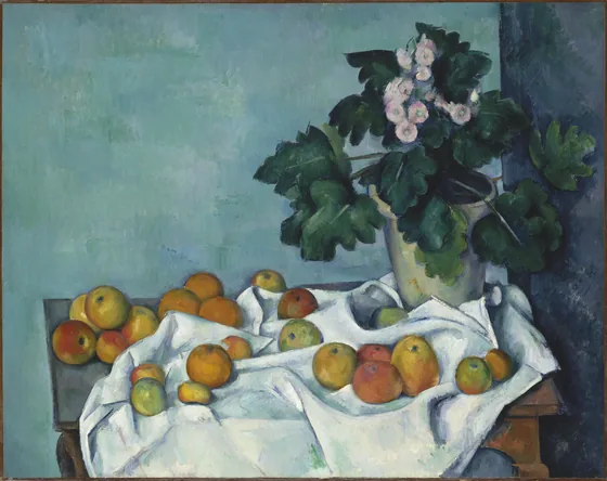 Pot de primevères et fruits sur une table