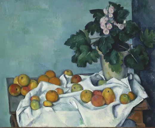 Pot de primevères et fruits sur une table